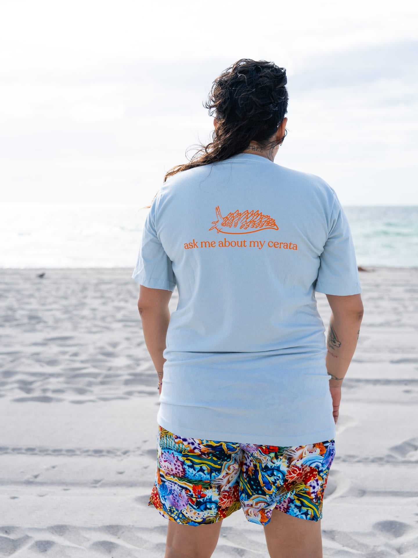 Nudi Nerd printed on the front and "ask me about my cerata" on the back of a blue organic cotton tee