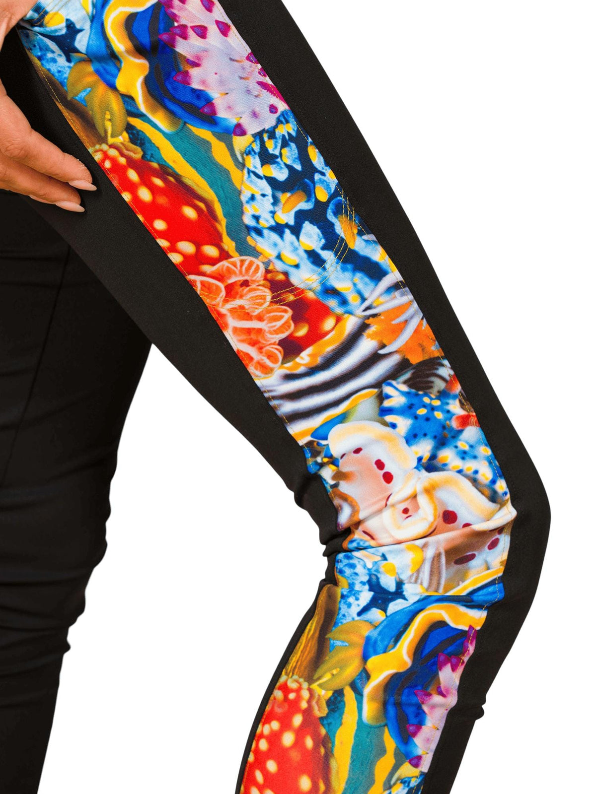Close up of a bright colorful nudibranch print along the side of the leg of a black legging.