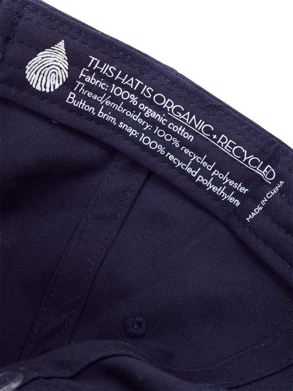 Close up image of the interior label of a blue organic cotton dad cap hat